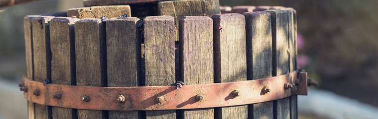 Winepress with red must and helical screw. Traditional old technique of wine making. Filtering grape must.