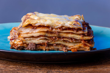 portion of fresh lasagna on a blue plate