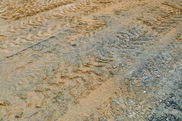 Texture of a dirty bad dirt road dirt road with puddles and clay drying mud with cracks and ruts. Off-road. The background