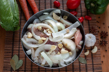 A piece of turkey meat with onions and spices for baking