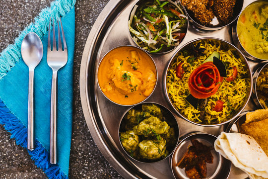 High angle close up of traditional Indian lunch with rice, various curries, pickles, and vegetables.,Goa