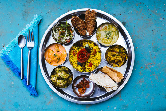High angle close up of traditional Indian lunch with rice, various curries, pickles, and vegetables.,Goa