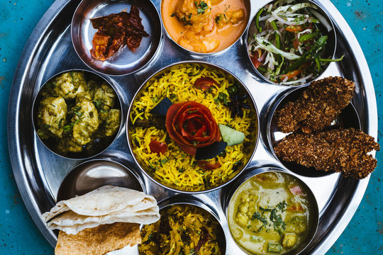 High angle close up of traditional Indian lunch with rice, various curries, pickles, and vegetables.,Goa