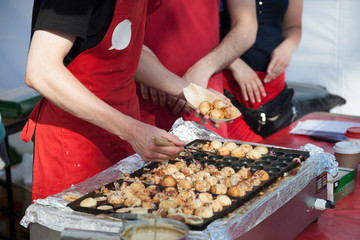 Cooking takoyaki on open air