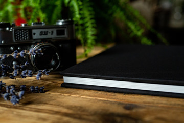 Edge of black book on wooden table.