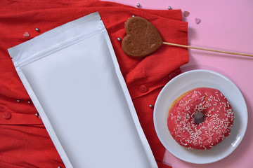 Paper packaging template on the background of romantic elements and a sweet donut. Mocap for branding your product on the package. Stock photo for design