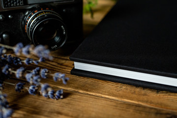 Edge of black book on wooden table.