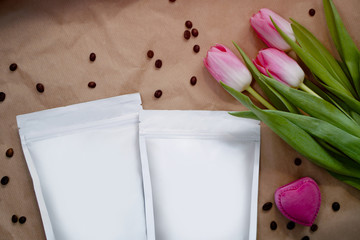 Beautiful spring bouquet with a pack of coffee for your decoration. Template for your brand on the packaging. Layout for the design of your logo