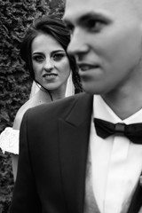 Beautiful bride and groom embracing and kissing on their wedding day. Happy romantic young couple celebrating their marriage