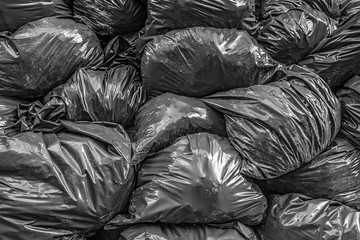 Fototapeta na wymiar Large pile of black shiny bin bags filled with rubbish.