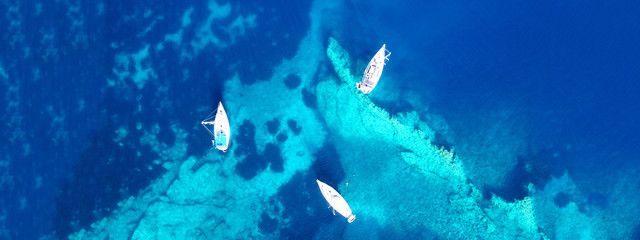 Aerial drone ultra wide photo of sail boat docked in tropical exotic bay with turquoise clear sea