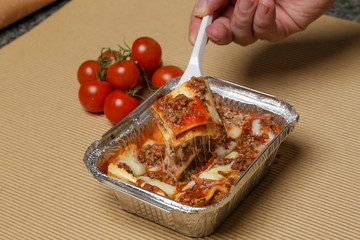 Lasagna takeaway package- Healthy Italian food in foil box - obrazy, fototapety, plakaty