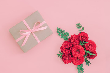 Gift or present box wrapped in kraft paper and rose flower on pi