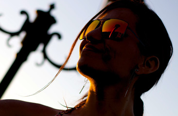 Mujer mira un atardecer desde la penumbra