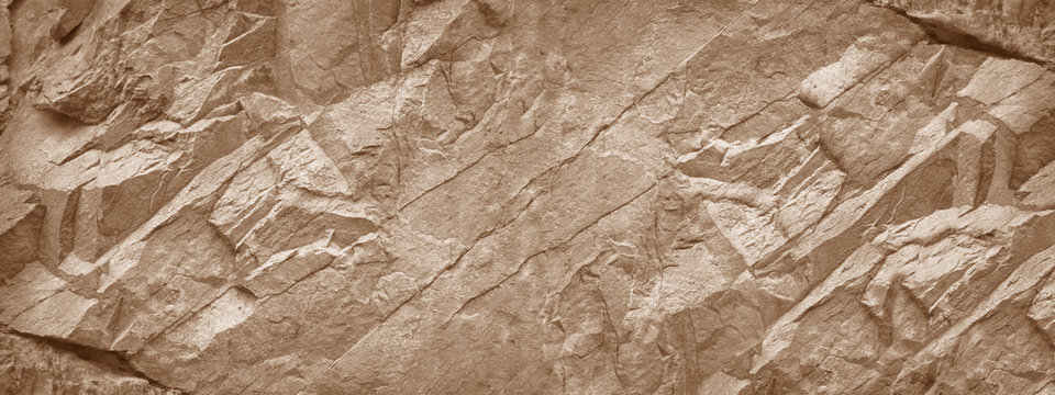 Stone wall. Light brown rock texture. Stone grunge backdrop. Rocky texture background with copy space for design. Web banner. Wide. Panoramic.