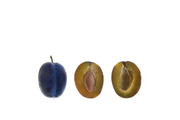 ripe halved and whole prune plums on white background with copy space above