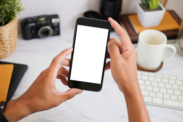 Cropped shot view of woman hands holding smart phone with blank copy space screen for your text message or information content, female reading text message on cell telephone during in urban setting. 