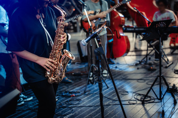 Musician playing on thesaxophone. Musician plays a musical instrument on the concert stage