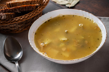 Fish soup in a plate on a brown background