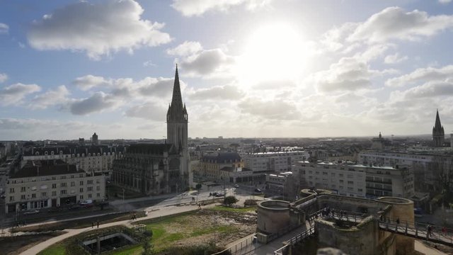 Time lapse in the city centre of Caen in Normandy, France. View on a church. Sun in front of the camera, some clouds in the sky. Filmed in the winter.
