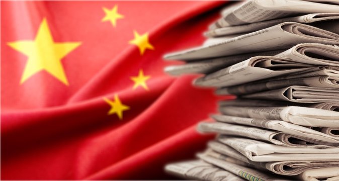 Pile of newspapers stacks on china flag background