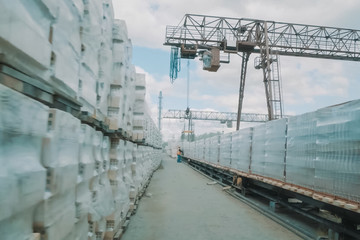 Bricks are stored in an open air warehouse. Red brick in pallets