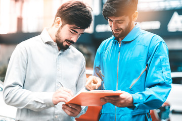 Obraz premium Car Mechanic Ready For Work. Auto Mechanic with Large Wrench in Hands. Ideas How to Fix the Problem.Male mechanics at the garage fixing a car.Closed up focus .