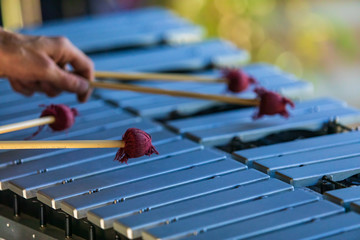 A close up shot on the hands of a person using four mallets to play a traditional vibraphone, a...