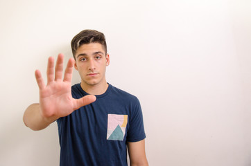 Young man making stop sign with hand