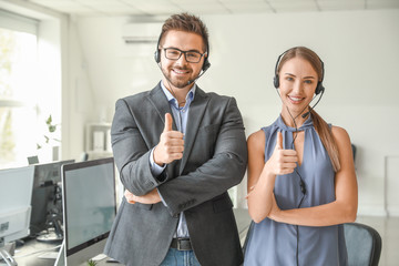 Portrait of technical support agents showing thumb-up in office