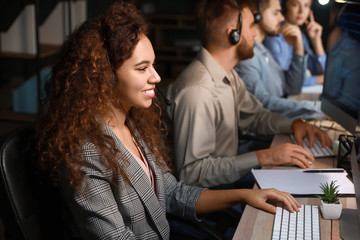 Technical support agents working in office at night