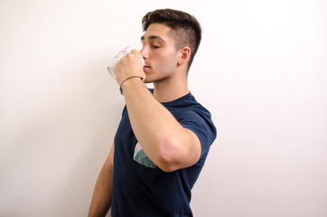 Young man drinking from a jug