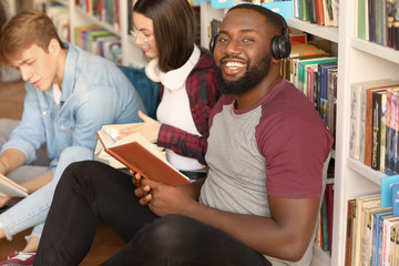 African-American student with friends preparing for exam in library