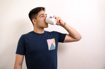 Young man drinking from a jug