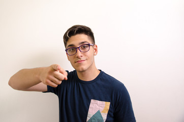 Young man with glasses pointing with index finger