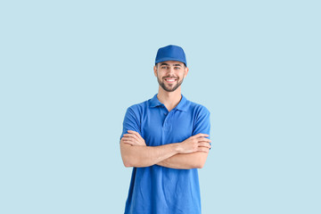 Handsome delivery man on color background