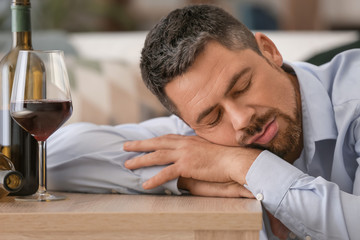 Drunk mature man at home. Concept of alcoholism