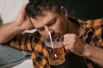 Mature man drinking beer at home. Concept of alcoholism