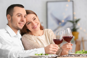 Happy young couple drinking wine on romantic date in cafe