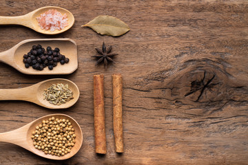 Various spices on rusty wooden background, black pepper, cinnamon stick, star anise, fennel seed