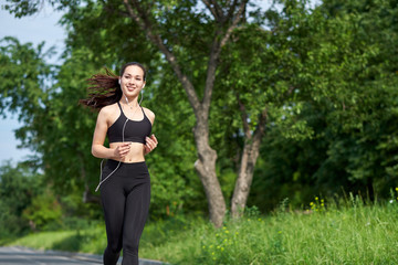 Young fitness asian woman running at forest trail.