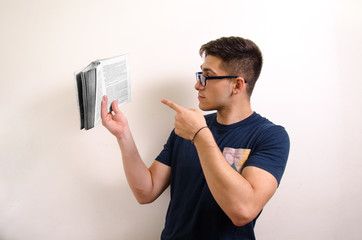 Young man with glasses and a book in his hand
