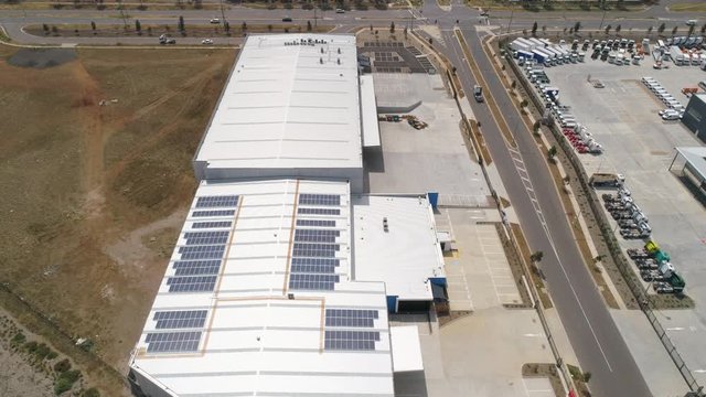 Solar panels installed on roof of a large warehouse aerial