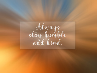 Inspirational motivational quote - Always stay humble and kind. With blurry digital motion effect background of dramatic colorful sky clouds.