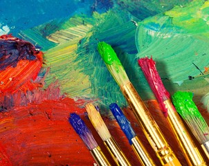 Artist's palette with oil paints and brushes for painting