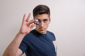 Young man with a miniature camera