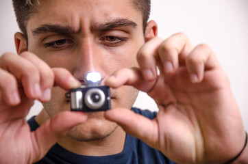 Young man with a miniature camera