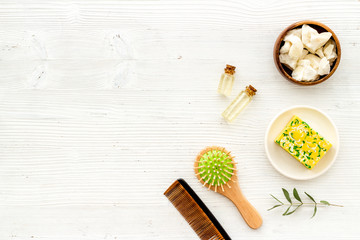 Cosmetics for hair care with argan and jojoba oil on white background top-down frame copy space