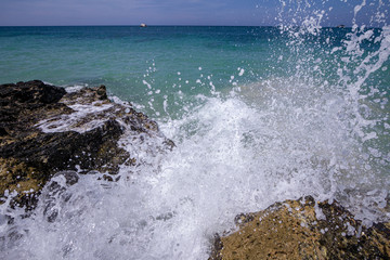 Waves crashing on a rocky shore in the tropics