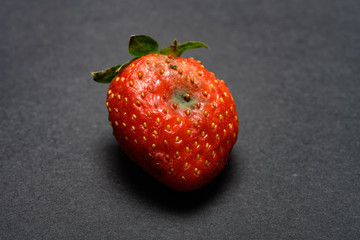over ripe strawberry on a dark background